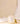 A lit white soy candle in a clear glass jar with a white label reading 'FLOURISH by Aesthetics' and 'Sunday Morning,' styled on a cream surface with draped white fabric and a small gold candle snuffer.